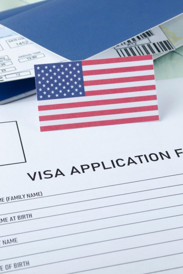USA visa application form with American flag, passport, and boarding pass – representing student visa application and approval for studying in the United States.