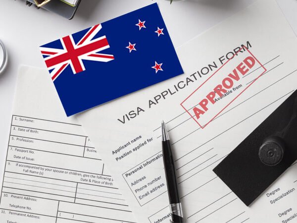 Close-up of New Zealand visa application form stamped “APPROVED” with the national flag on top, representing successful student visa approval for international education.