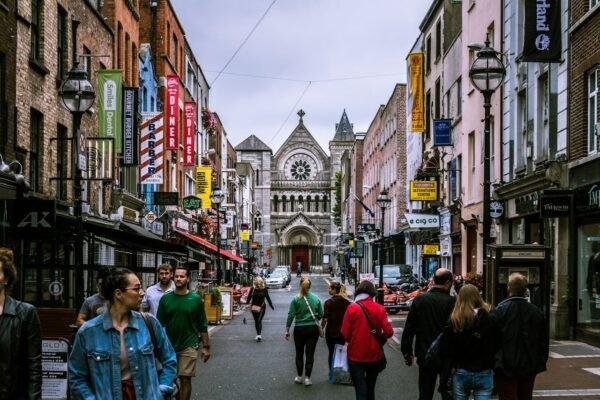 Busy pedestrian street in Dublin, Ireland with shops, restaurants, historic church, and student life – study abroad guidance from ASK Consultants.
