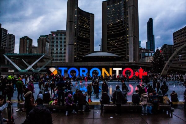 Nathan Phillips Square in Toronto with skating rink, illuminated Toronto sign, and City Hall towers – study in Canada with ASK Consultants Karachi.