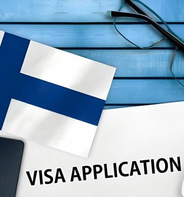Finland flag with passport and visa application form on a blue surface, showcasing study abroad and student visa services by ASK Consultants.