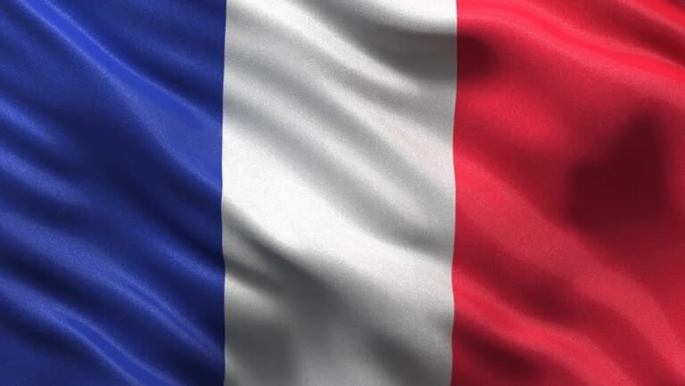 Close-up of the French tricolour flag (blue, white, red) with satin texture and ripples – plan your study abroad with ASK Consultants.