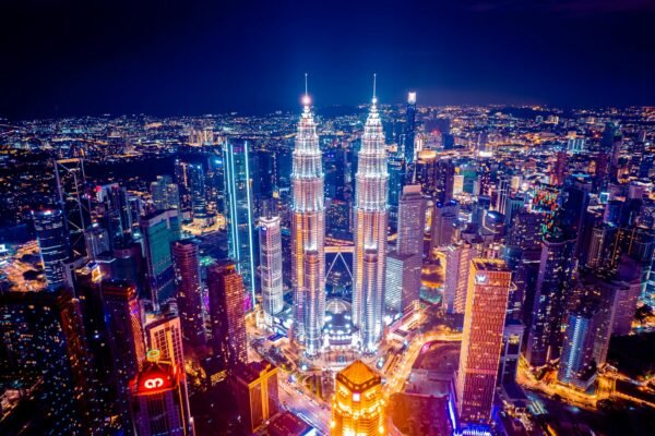 Aerial view of glowing Petronas Twin Towers in Kuala Lumpur at night, highlighting Malaysia as a top study abroad destination.